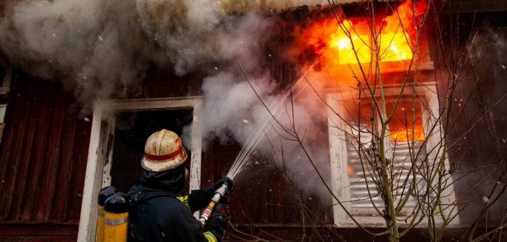 Pompier en train d'éteindre un incendie domestique
