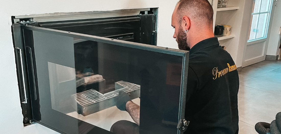 Technicien de Provence Ramonage effectuant l’entretien d’un insert de cheminée à foyer fermé.