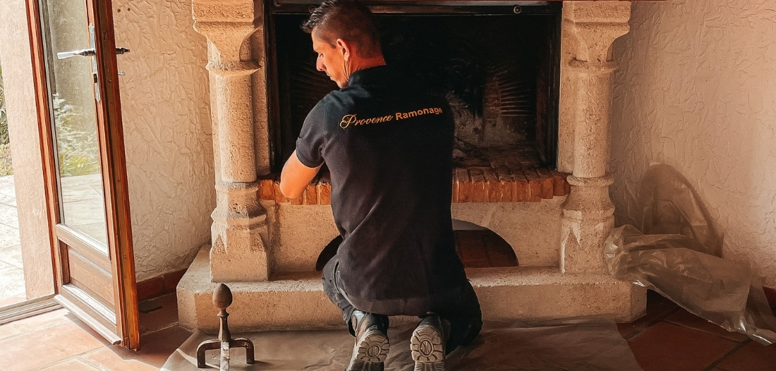 Technicien de Provence Ramonage préparant une cheminée rustique en pierre pour une intervention de ramonage.